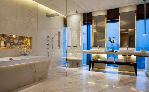 a bathroom with two sinks and a tub and a shower at Grand Hyatt Shenyang in Shenyang