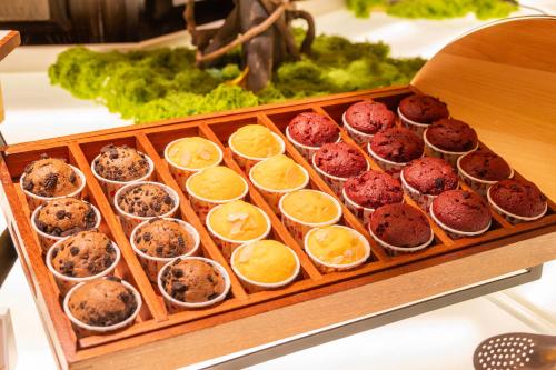 a tray of cupcakes with oranges and muffins at Shangri-La Harbin in Harbin