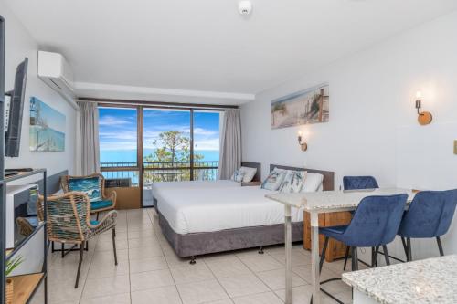 ein Hotelzimmer mit Bett, Tisch und Stühlen in der Unterkunft Bayview Tower in Yeppoon