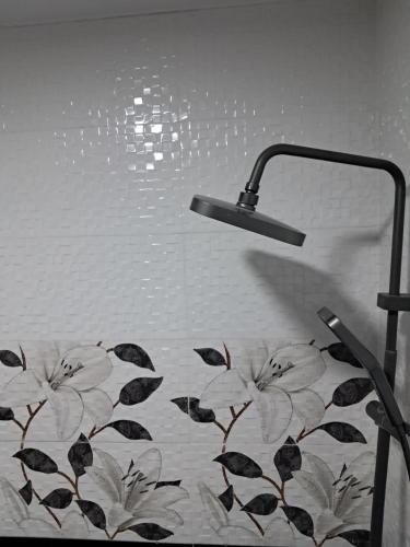 a bathroom with a shower with a floral shower curtain at Hotel Kazbegi11 in Ach'khoti
