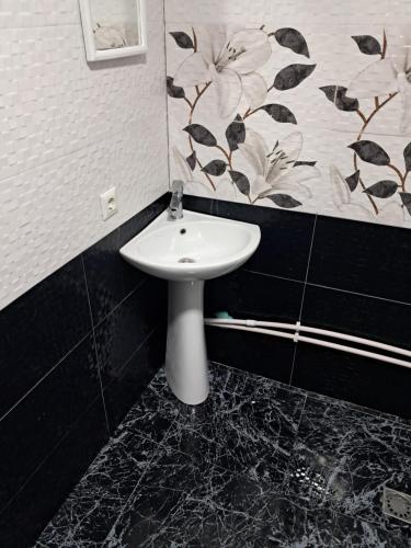 a bathroom with a sink and a flower pattern on the wall at Hotel Kazbegi11 in Ach'khoti