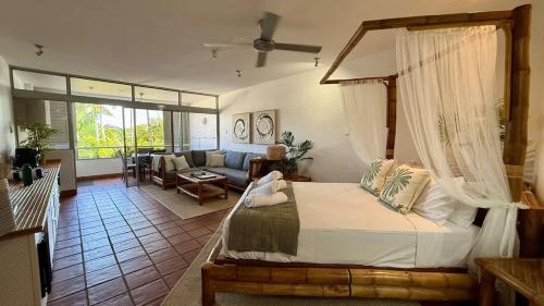a bedroom with a bed and a living room at Bella Vista Coral Sea Views in Port Douglas