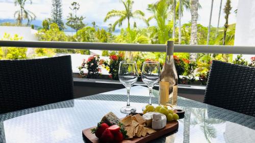 a table with two glasses and a bottle of wine at Bella Vista Coral Sea Views in Port Douglas