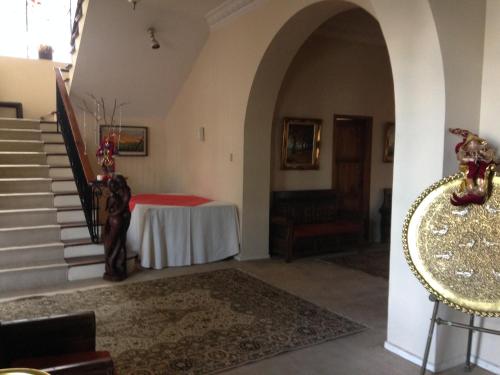 a hallway with a table and stairs in a house at Mansion Samzara Hosteleria in Sangolquí