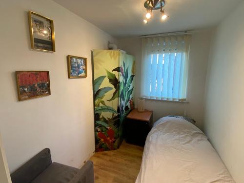a small bedroom with a bed and a window at Woning met 4 slaapkamers in Zelzate