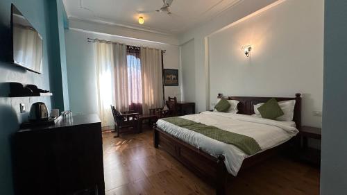 a bedroom with a bed and a desk and a window at The Ranthambore Samrajya Tiger Seven in Sawāi Mādhopur