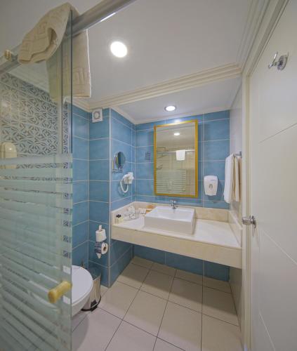 ein Badezimmer mit Badewanne, Waschbecken und Dusche in der Unterkunft Side Aluna Hotel in Side
