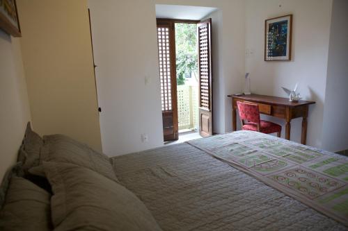 a bedroom with a bed and a desk and a window at Pousada Irradiante in Olinda