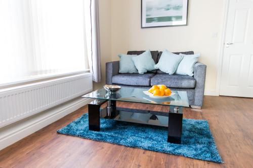a living room with a couch and a glass table at Church View Irene Court Cockermouth in Cockermouth