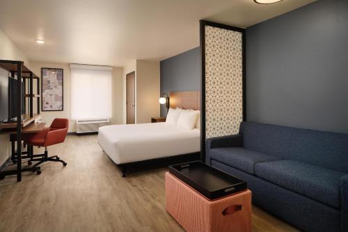 a hotel room with a bed and a couch at Hyatt Studios Kalispell in Kalispell