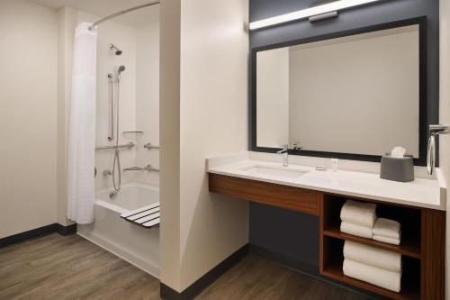 a bathroom with a sink and a shower and a mirror at Hyatt Studios Kalispell in Kalispell