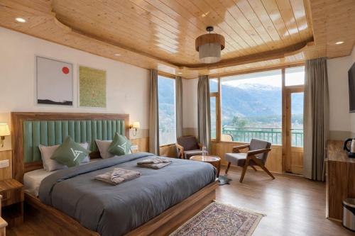a bedroom with a bed and a large window at The Trippy Tribe Manali in Manāli