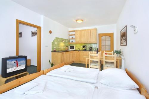 um quarto com uma cama e uma cozinha em Apartment Bílé Labe 38 em Špindlerŭv Mlýn