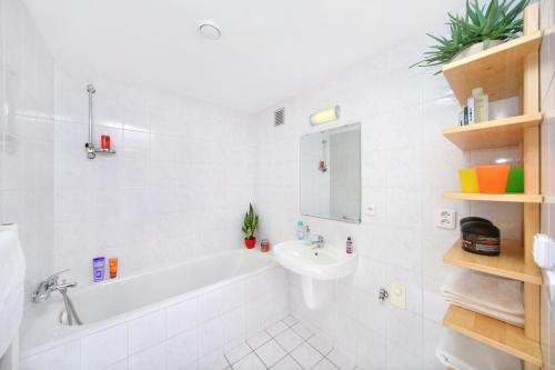 a white bathroom with a tub and a sink at Apartment Bílé Labe 38 in Špindlerův Mlýn