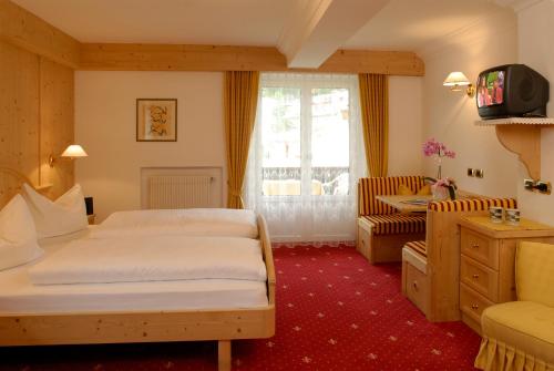 pokój hotelowy z dwoma łóżkami i telewizorem w obiekcie Garni Waltoy w mieście Selva di Val Gardena