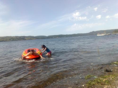 a woman and a child in the water with an inner tube at Cabañas Quito in Compu