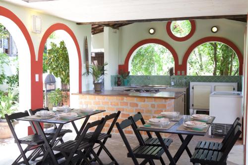 a patio with two tables and chairs and a kitchen at Irradiante in Olinda