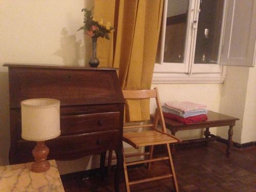 a desk and a chair next to a dresser and a window at House Steccuto in Florence