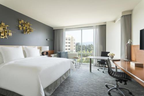 a hotel room with a large bed and a desk at Four Seasons Hotel Silicon Valley at East Palo Alto in Palo Alto