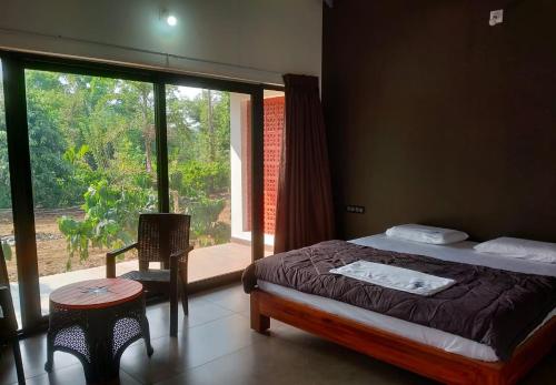 a bedroom with a bed and a large window at Aarna the Baane in SanivÄrsante
