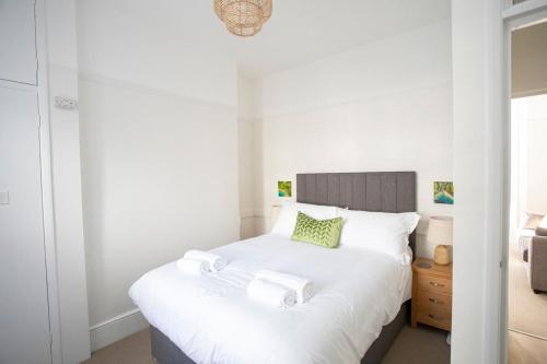 a bedroom with a white bed with towels on it at Pebble Hideaway in Worthing