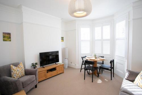 a living room with a table and a tv at Pebble Hideaway in Worthing