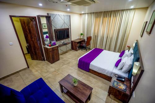 a bedroom with a bed and a desk and a tv at Anna Residency The Quintessential Boutique Hotel in Pondicherry