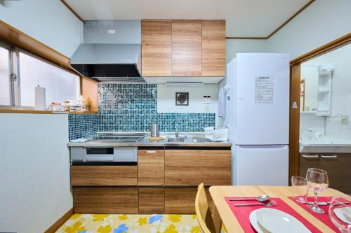 a kitchen with a table and a white refrigerator at Fukurou House in Tokyo