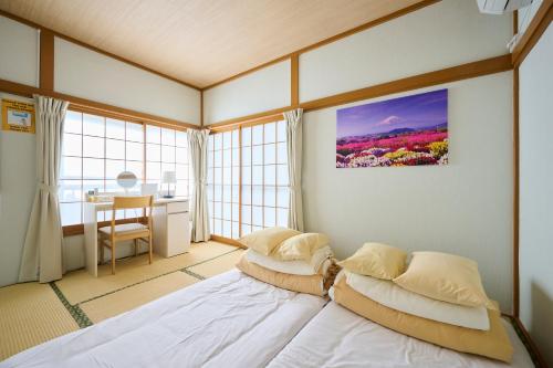 a bedroom with two beds in a room with windows at Fukurou House in Tokyo