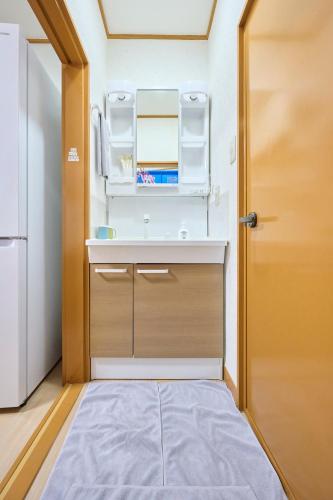 a small kitchen with a sink and a door at Fukurou House in Tokyo