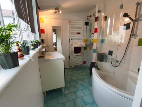 a bathroom with a tub and two sinks and a shower at La petite Tourelle Ruelle de la Fontaine in Péronne