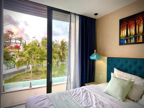 a bedroom with a bed and a large window at 719 - Villa Oceanami - Phước Hải in Long Hai