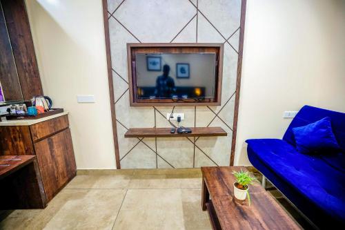 a living room with a blue couch and a tv at Anna Residency The Quintessential Boutique Hotel in Pondicherry