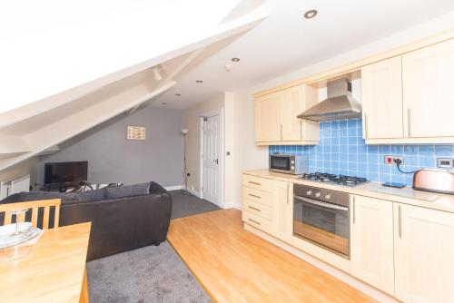 a kitchen and a living room with a couch at Flex Lets - Azalea Terrace Apartments in Sunderland