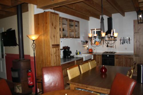 een keuken met een tafel en stoelen en een fornuis bij Landhuis "Op de Heugte" in Norg