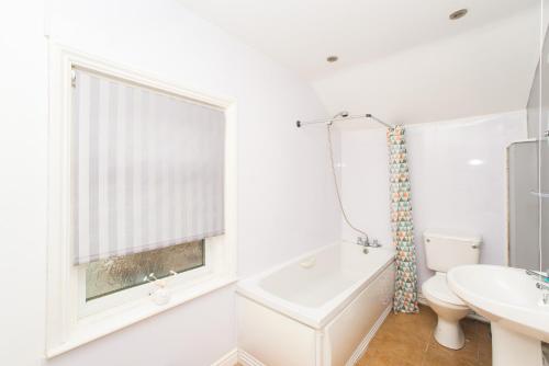 een badkamer met een wastafel, een toilet en een raam bij Flex Lets - Azalea Terrace Apartments in Sunderland