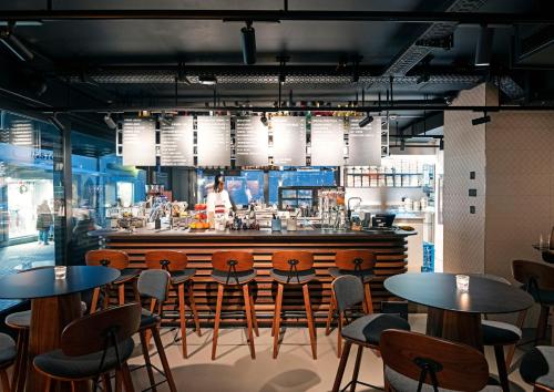 a restaurant with tables and chairs and a bar at The Lubo - self check-in in Lucerne