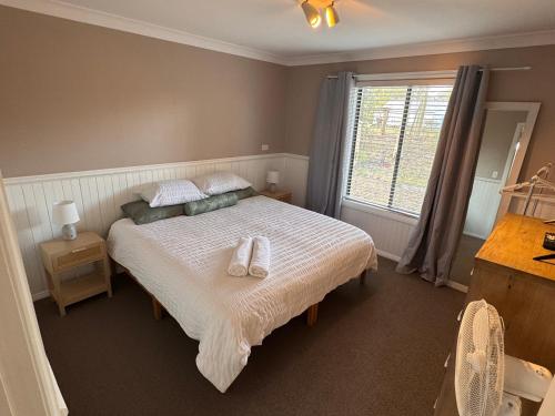 a bedroom with a bed with two towels on it at Singleton Rose Cottages in Singleton