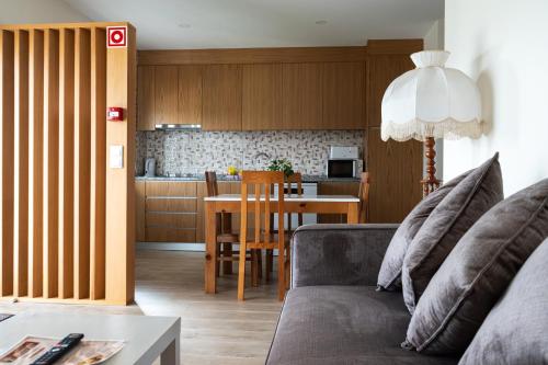 a living room with a couch and a table and a kitchen at O Paraíso do Sobreiro - Country House in Travanca de Lagos