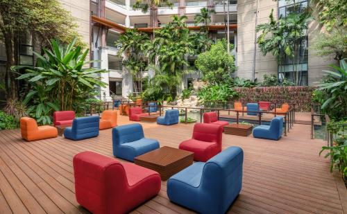 a group of colorful chairs and tables in a courtyard at Hilton Bangkok Suvarnabhumi Golf Resort & Spa in Lat Krabang
