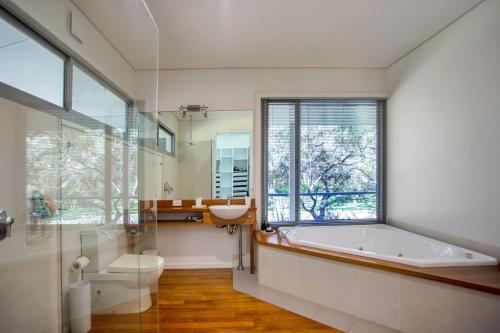 a bathroom with a tub and a sink and a window at The Banksia's in Tea Gardens