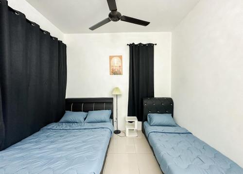 a bedroom with two beds and a ceiling fan at Kulim Modern Bungalow in Kulim