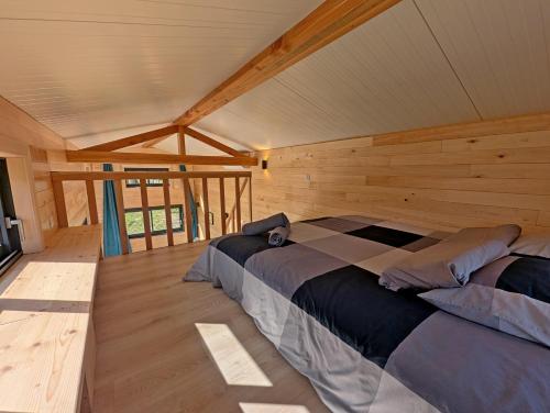 a bedroom with a bed in a log cabin at La Parenthèse Romantique in Saint-Martin-de-la-Mer