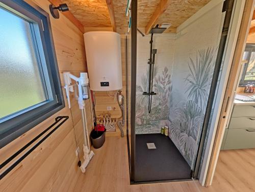 a small bathroom with a shower in a tiny house at La Parenthèse Romantique in Saint-Martin-de-la-Mer