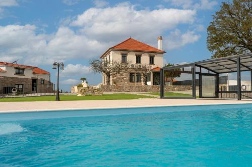 a house with a swimming pool in front of a house at O Paraíso do Sobreiro - Country House in Travanca de Lagos