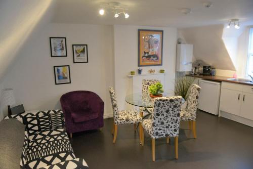 eine Küche und ein Esszimmer mit einem Tisch und Stühlen in der Unterkunft The Loft at Venga in Portishead