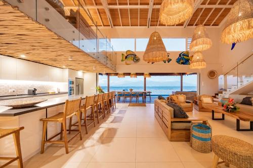 an open kitchen and living room with a view of the ocean at Villa Tohora in Teavaro