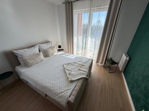 a bedroom with a bed and a large window at Apartament Staromiejski Rapackiego 45 in Grudziądz
