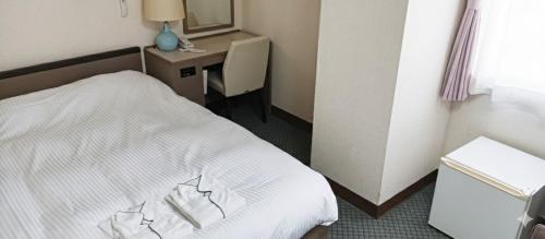 a hotel room with a bed and a desk at Tetora Higashimuroran in Muroran