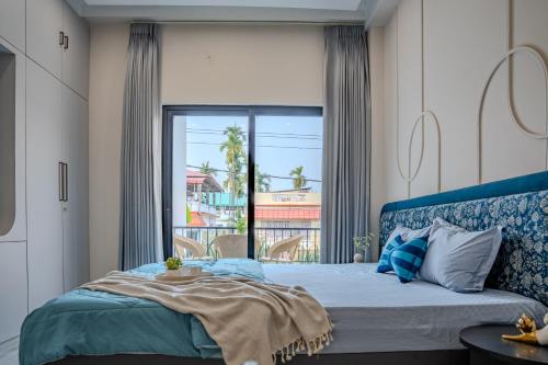 a bedroom with a bed and a large window at Villa Aura in Siliguri